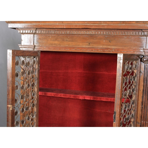 632 - AN ITALIAN WALNUT CUPBOARD, having a flared and dentil cornice above a deep frieze and two iron gril... 