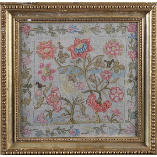 7 - AN 18TH CENTURY NEEDLEWORK PANEL of birds amongst flowering branches within a border of trailing flo... 