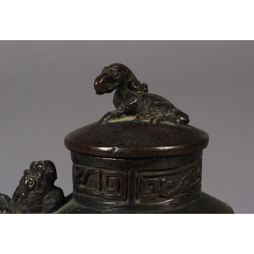 88 - A SMALL CHINESE BRONZE WINE POT, 18TH CENTURY, the domed cover with mythical creature finial, the ov... 