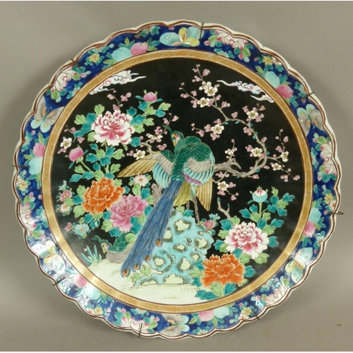 97B - A 19TH CENTURY CHINESE FAMILLE NOIR SHAPED CIRCULAR CHARGER, decorated in polychrome enamels with a ... 