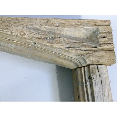 568 - A 17TH CENTURY STYLE OAK DOOR FRAME with pair of fluted trunk uprights, the header with shallow geom... 