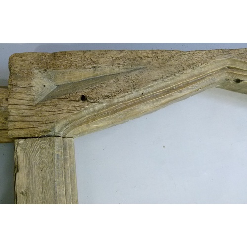 568 - A 17TH CENTURY STYLE OAK DOOR FRAME with pair of fluted trunk uprights, the header with shallow geom... 