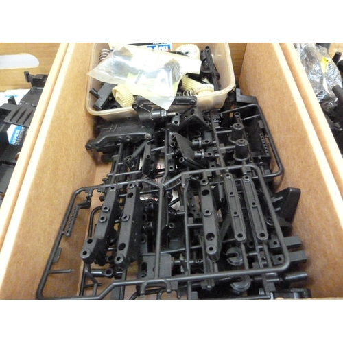 39 - A quantity of spare model parts to include plastic mouldings, chassis, etc. in four boxes (4)