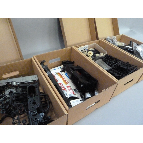 39 - A quantity of spare model parts to include plastic mouldings, chassis, etc. in four boxes (4)