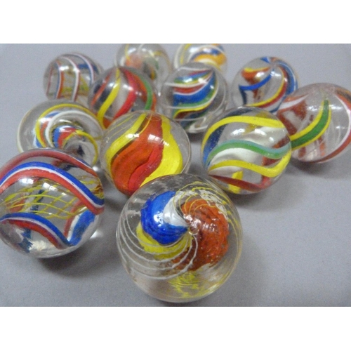 4 - A collection of twelve vintage marbles to include two with solid white core, two with yellow, red an... 