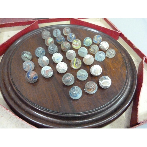 7 - An early 20th century solitaire game with turned walnut board and thirty-three marbles (some affecte... 