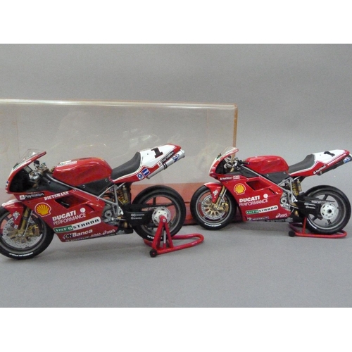 91 - Minichamps 1:12 Ducati 996 Superbike 1999 and 2000 Carl Fogarty, both boxed, together with a display... 