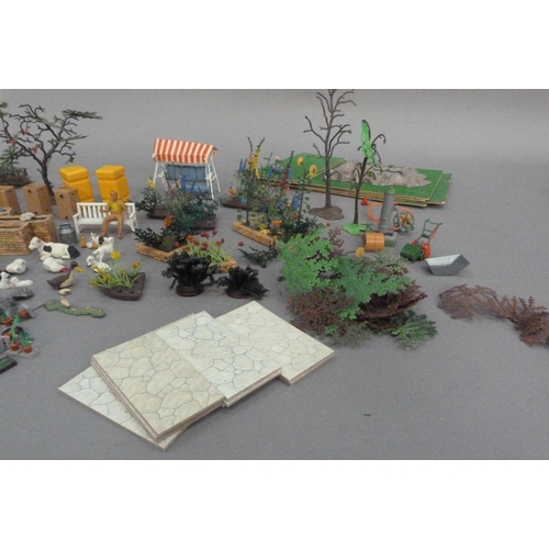 115 - A Britains plastic model toy garden with hedgerows, shrubs and plants, greenhouse, flowerberds, rock... 