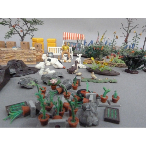 115 - A Britains plastic model toy garden with hedgerows, shrubs and plants, greenhouse, flowerberds, rock... 