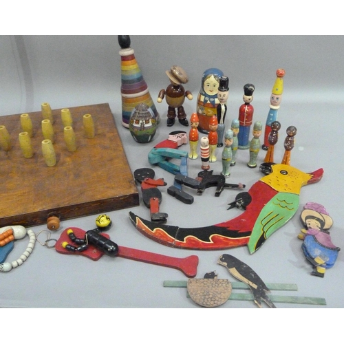 235 - A bar skittles game together with a collection of painted wooden toys including a balancing parrot, ... 