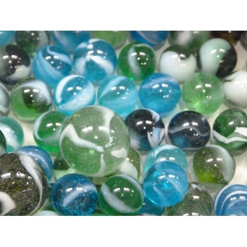 244 - A collection of vintage marbles to include shades of green to blue with a white swirl (approximately... 