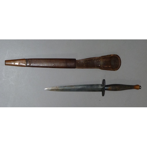 295B - A WWII Fairbairn-Sykes fighting knife having a brass cross-hatched grip and rounded pommel, oval 5cm... 