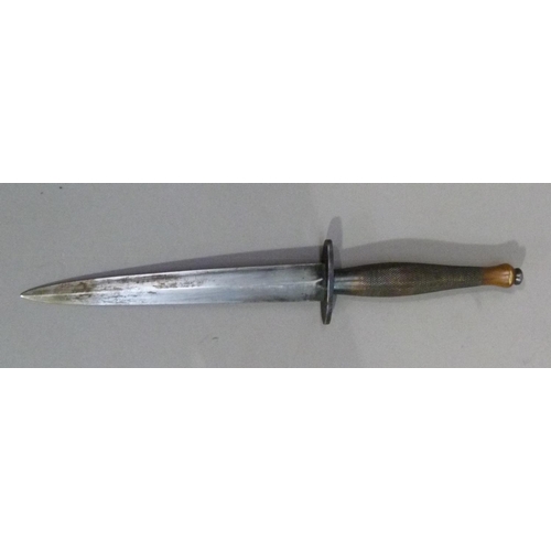 295B - A WWII Fairbairn-Sykes fighting knife having a brass cross-hatched grip and rounded pommel, oval 5cm... 