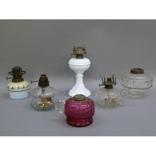 178 - Six assorted oil lamps including a cranberry glass lamp base with clear glass handle