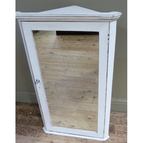 122 - A white painted wooden hanging corner cabinet with flared cornice above a mirrored door, 114cm high