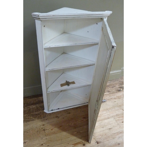 122 - A white painted wooden hanging corner cabinet with flared cornice above a mirrored door, 114cm high