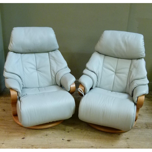 133 - A pair of German Himolla pale grey leather reclining and revolving easy chairs on steam bent frames,... 