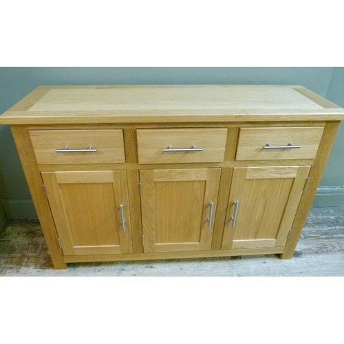 134 - An oak extending dining table, together with a set of four rail back dining chairs with oatmeal colo... 