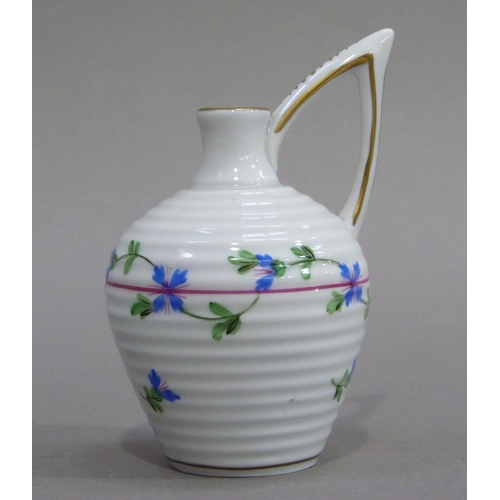 4 - A Herend miniature jug of ribbed form with high angular handle, painted with trailing blue flowers, ... 