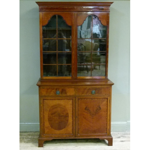387 - A George III style mahogany bookcase cabinet the flared cornice above a figured frieze and pair of a... 