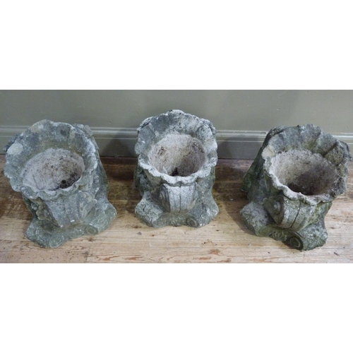 395 - A set of three reconstituted concrete shell planters, each supported on a scrolling corbel, 35cm x 3... 