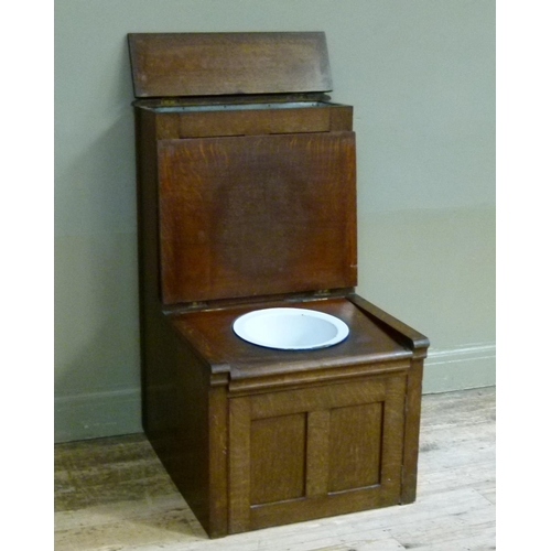 402 - British Sanitary Company, Glasgow - an oak commode the hinged seat revealing enamelled liner above d... 
