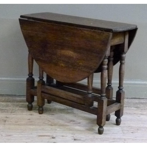 416 - An oak gate-leg table, the oval top above turned legs joined by moulded square stretchers, 80cm wide