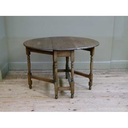 416 - An oak gate-leg table, the oval top above turned legs joined by moulded square stretchers, 80cm wide