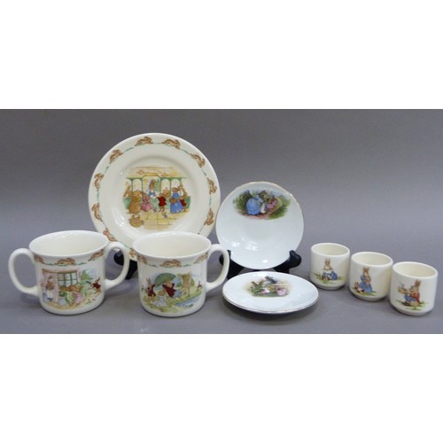 155 - A Bunnykins mug, a two handled mug, three egg cups, a plate, together with two Peter rabbit saucers