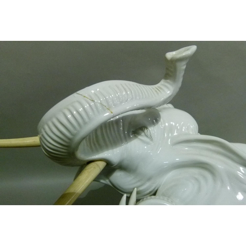 37 - A white pottery figure of an elephant with ivorine tusks, 35cm high