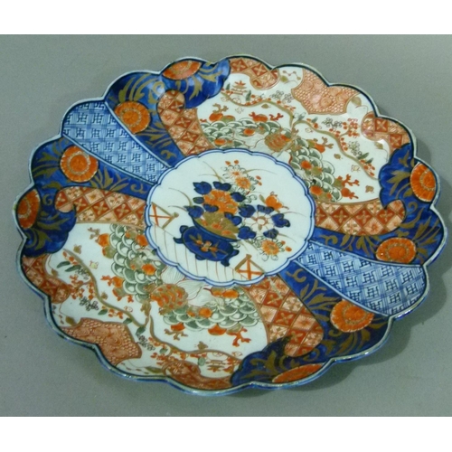 66 - A Japanese Imari petal shaped dish decorated in typical palette, the centre with vase of flowers wit... 