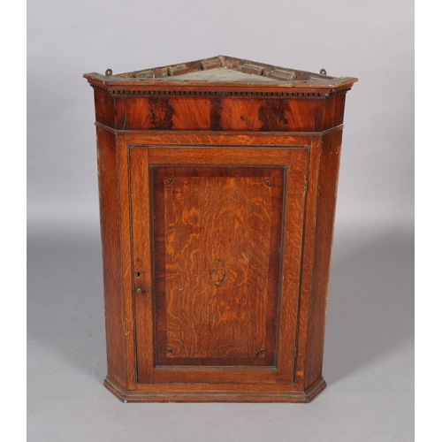 123 - A George III oak hanging corner cupboard with dentil moulded cornice, the single panelled door revea... 