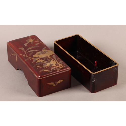 183 - A Japanese red lacquer box and cover of rounded rectangular form, the pull off lid decorated in brow... 