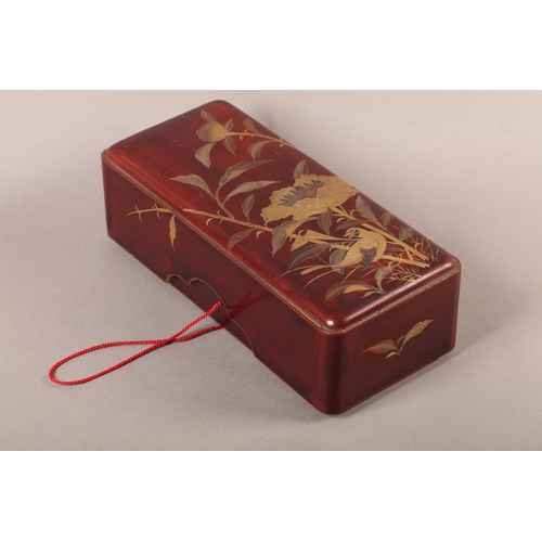 183 - A Japanese red lacquer box and cover of rounded rectangular form, the pull off lid decorated in brow... 