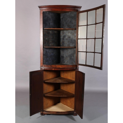 301 - A 19th century mahogany bow front standing corner cupboard, having a moulded cornice above a twelve ... 