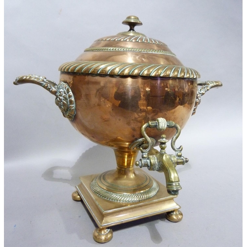 120 - A 19th century copper two handled tea urn with domed and fluted cover, brass spigot on a domed circu... 