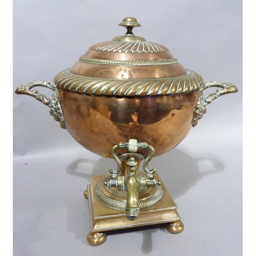 120 - A 19th century copper two handled tea urn with domed and fluted cover, brass spigot on a domed circu... 