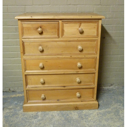 129 - A reproduction pine chest of drawers fitted with two short and four long panelled drawers, skirted p... 