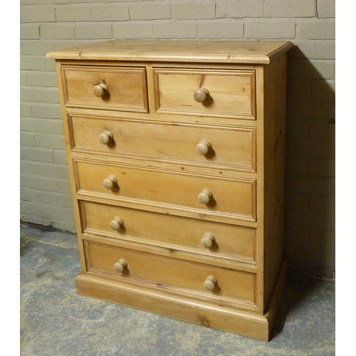 129 - A reproduction pine chest of drawers fitted with two short and four long panelled drawers, skirted p... 