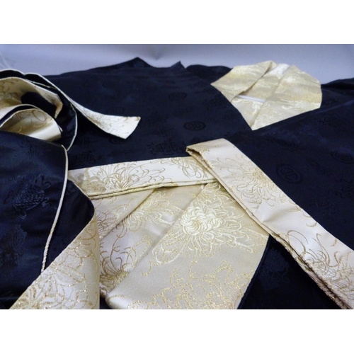 23 - A Japanese black and pale gold kimono embroided in gilt thread with chrysanthemum