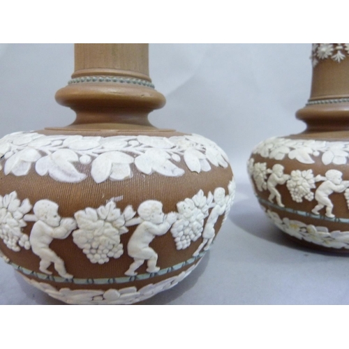 28 - A pair of Doulton silicon ware bottle vases and covers  with buff bodies, relief decorated with band... 