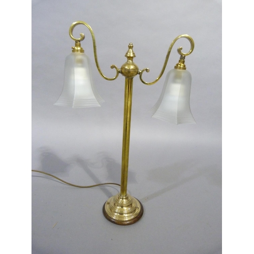 50 - A brass, two light table lamp having two scrolled arms with opaque shades, central column on a circu... 