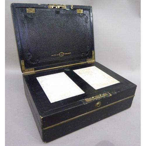 54 - A Victorian black leather and brass writing box having an inset handle to the cover, the interior fi... 