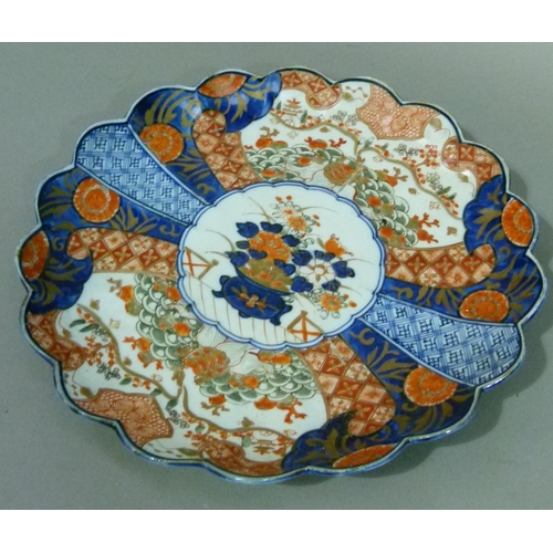 66 - A Japanese Imari petal shaped dish decorated in typical palette, the centre with vase of flowers wit... 