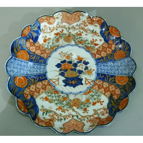 66 - A Japanese Imari petal shaped dish decorated in typical palette, the centre with vase of flowers wit... 