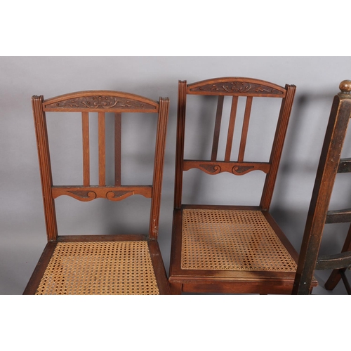 94 - A set of four oak dining chairs with carved top rails, three vertical slats, caned seats, turned leg... 