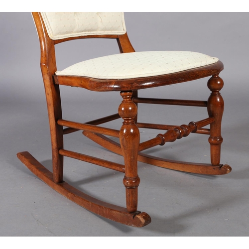 99 - A Victorian walnut stained beech rocking chair, the rounded back with buttoned upholstered panel, st... 