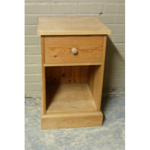 132 - A reproduction pine large bedside cabinet with plain top above frieze drawer and open compartment, s... 