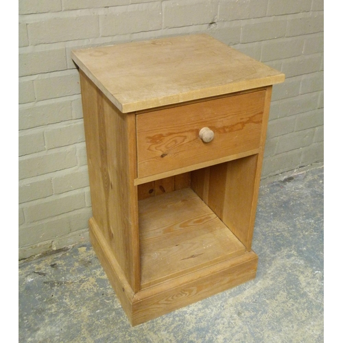 132 - A reproduction pine large bedside cabinet with plain top above frieze drawer and open compartment, s... 