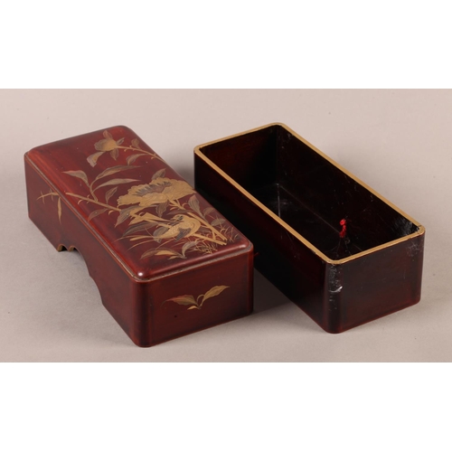 183 - A Japanese red lacquer box and cover of rounded rectangular form, the pull off lid decorated in brow... 